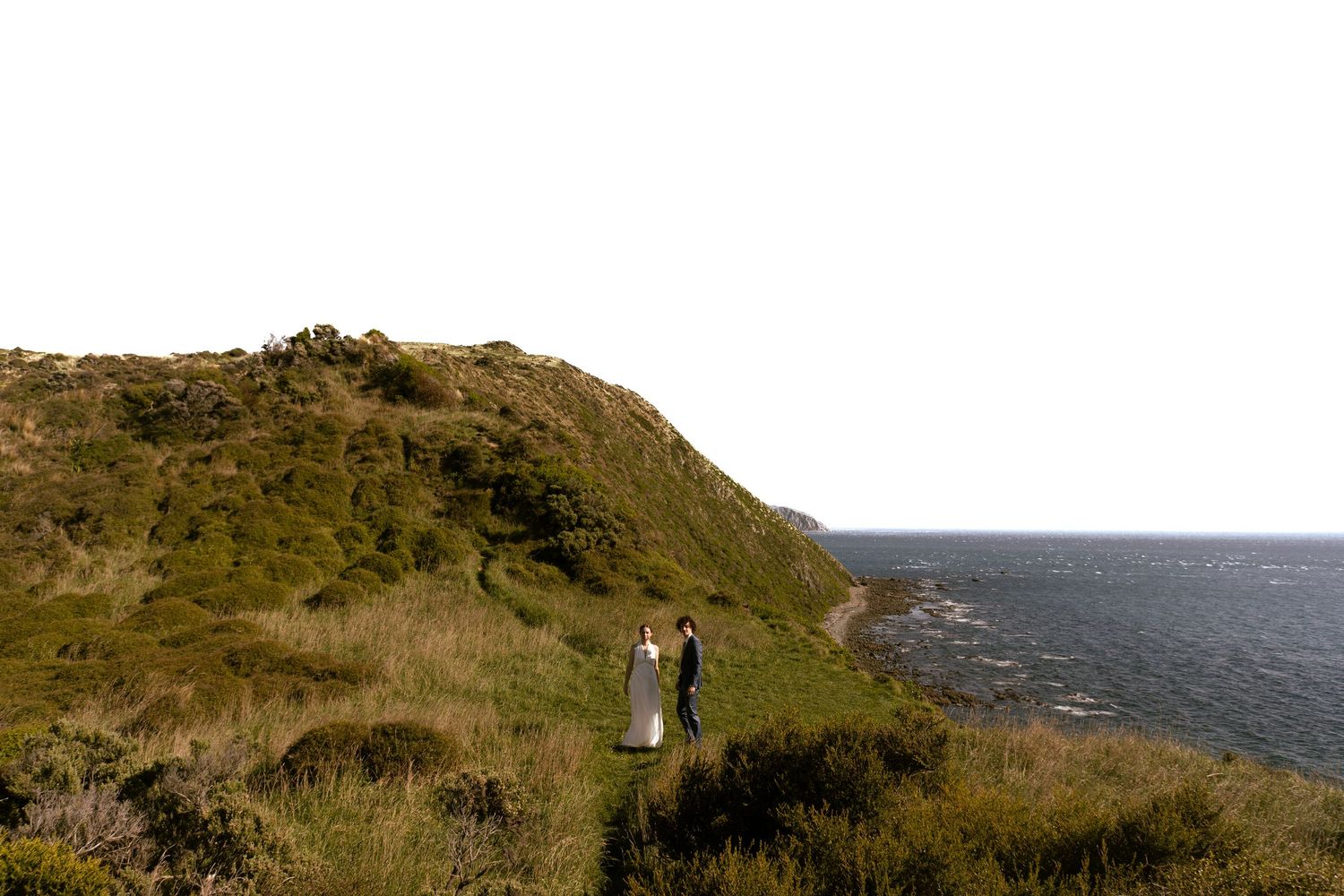 Dramatic coastal cliffside landscape with rocky outcrops against an ocean backdrop.