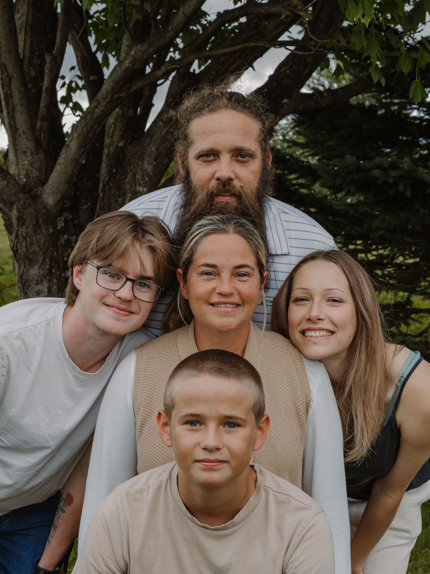 A family poses together, with mom in the middle.