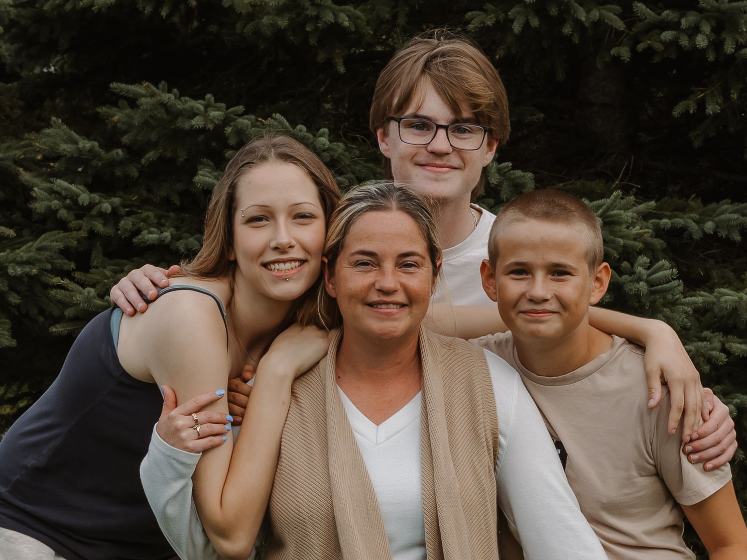 Teen kids pose with their mother.