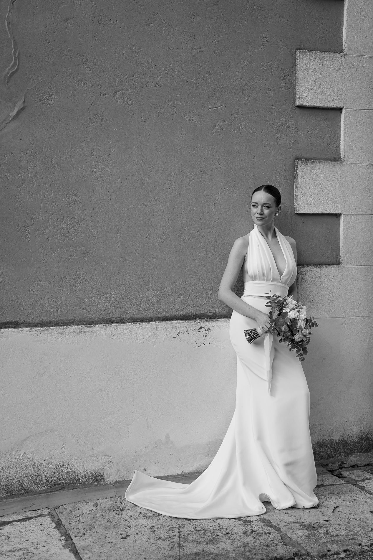 A black and white photo sequence shows a bride in a white wedding dress seated against a textured wall, Tuscany, Italy