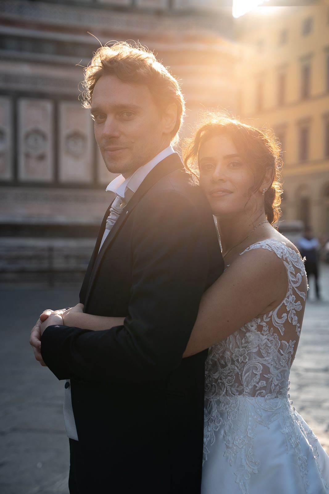 Romantic newlywed couple embraces during golden hour in an elegant setting during their elopement in Italy.