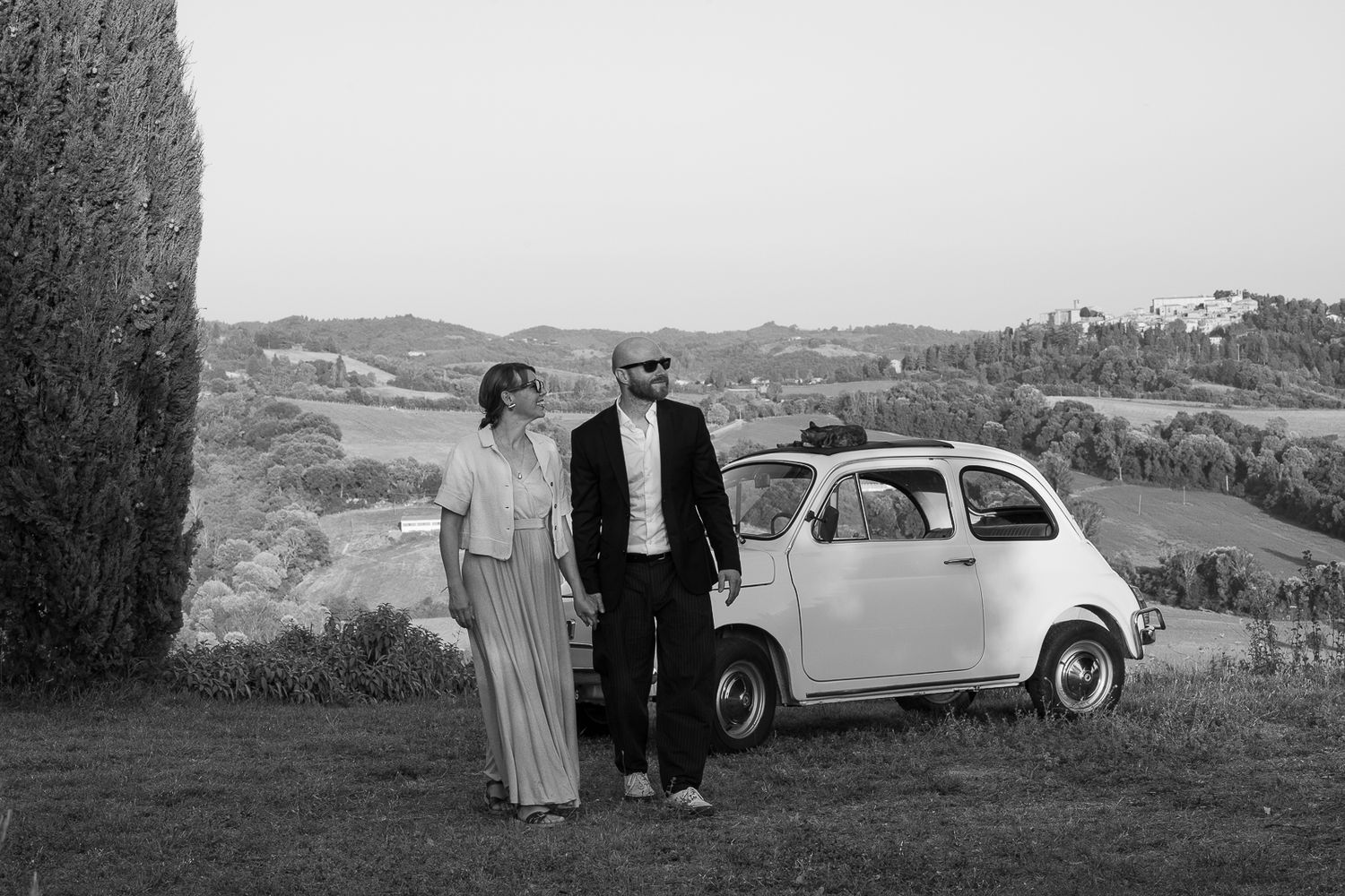 Panoramic countryside view with vintage car Fiat 500 and rolling hills in black and white overlooking Montone, Umbria,. Italy