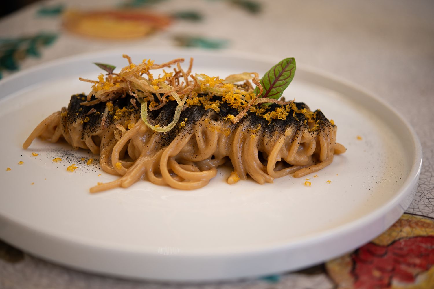 Elegant pasta dishes with various toppings and garnishes arranged on white plates in a fine dining presentation by Giancarlo Polito.