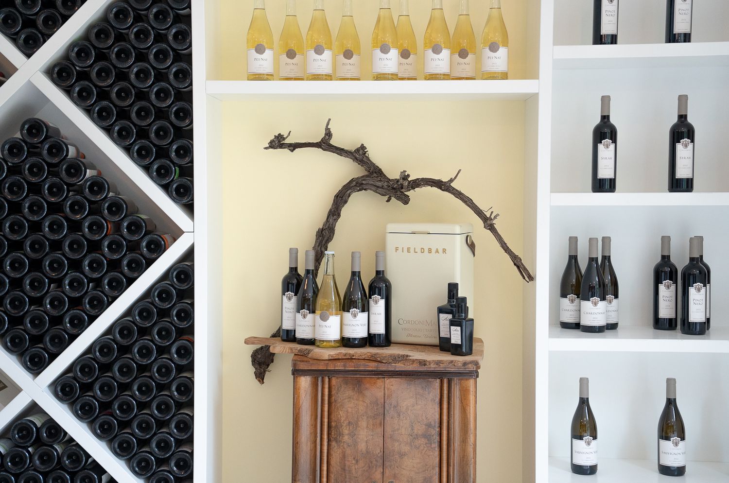 Wine bottles displayed on wooden shelves and racks in an elegant retail or cellar setting.