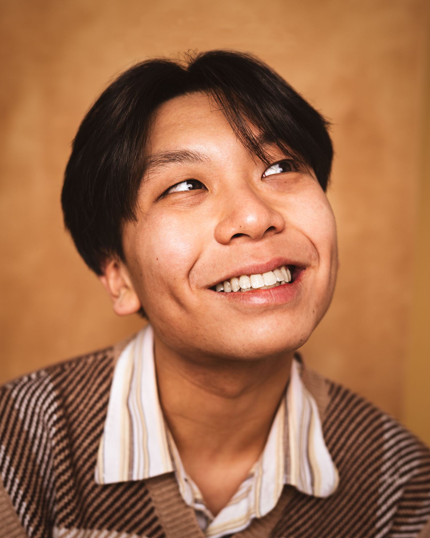 A series of five close-up portraits showing joyful expressions and genuine smiles against a warm brown background.