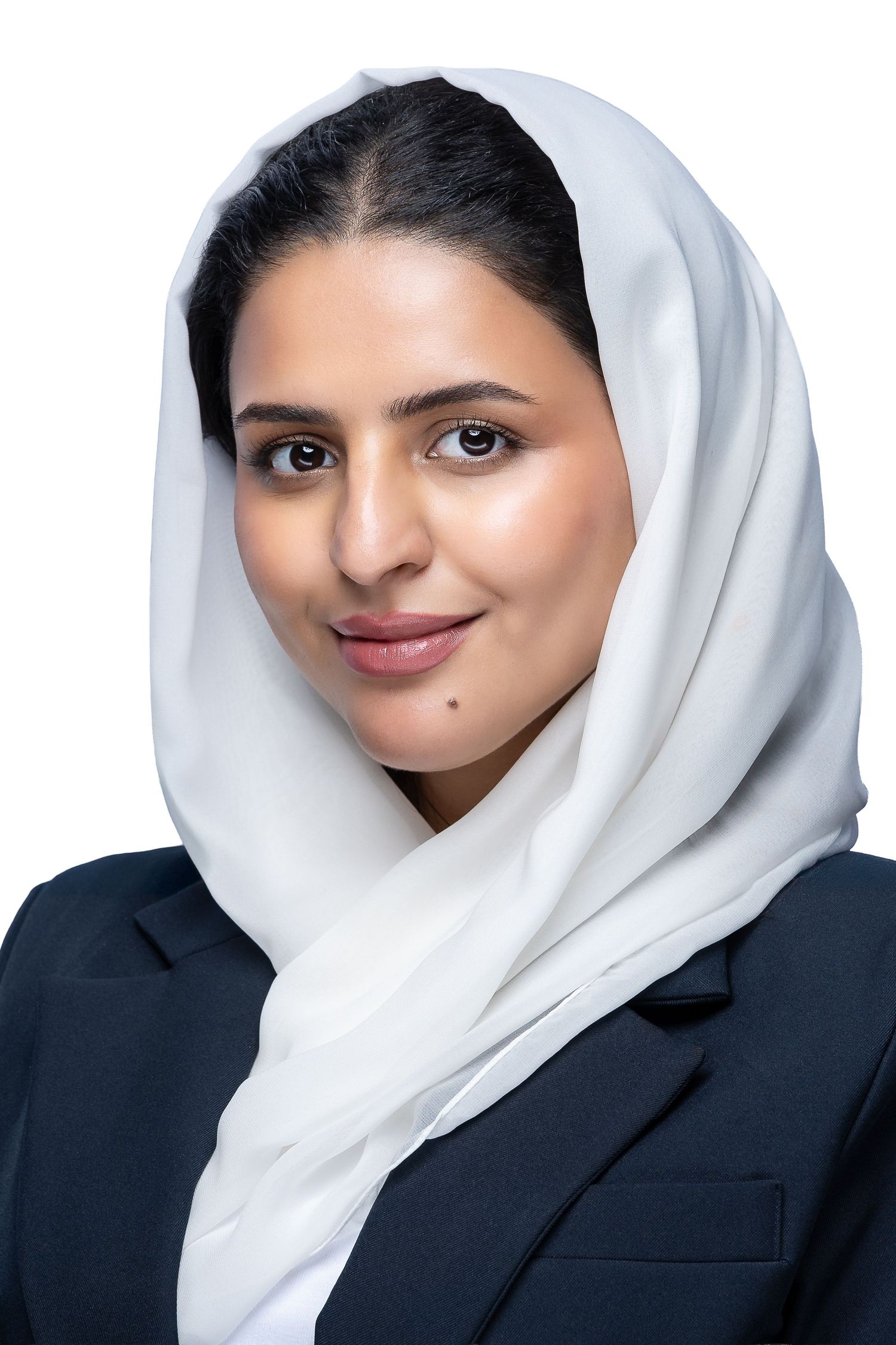 Professional portrait of someone wearing a crisp white hijab and navy blazer against a light background.