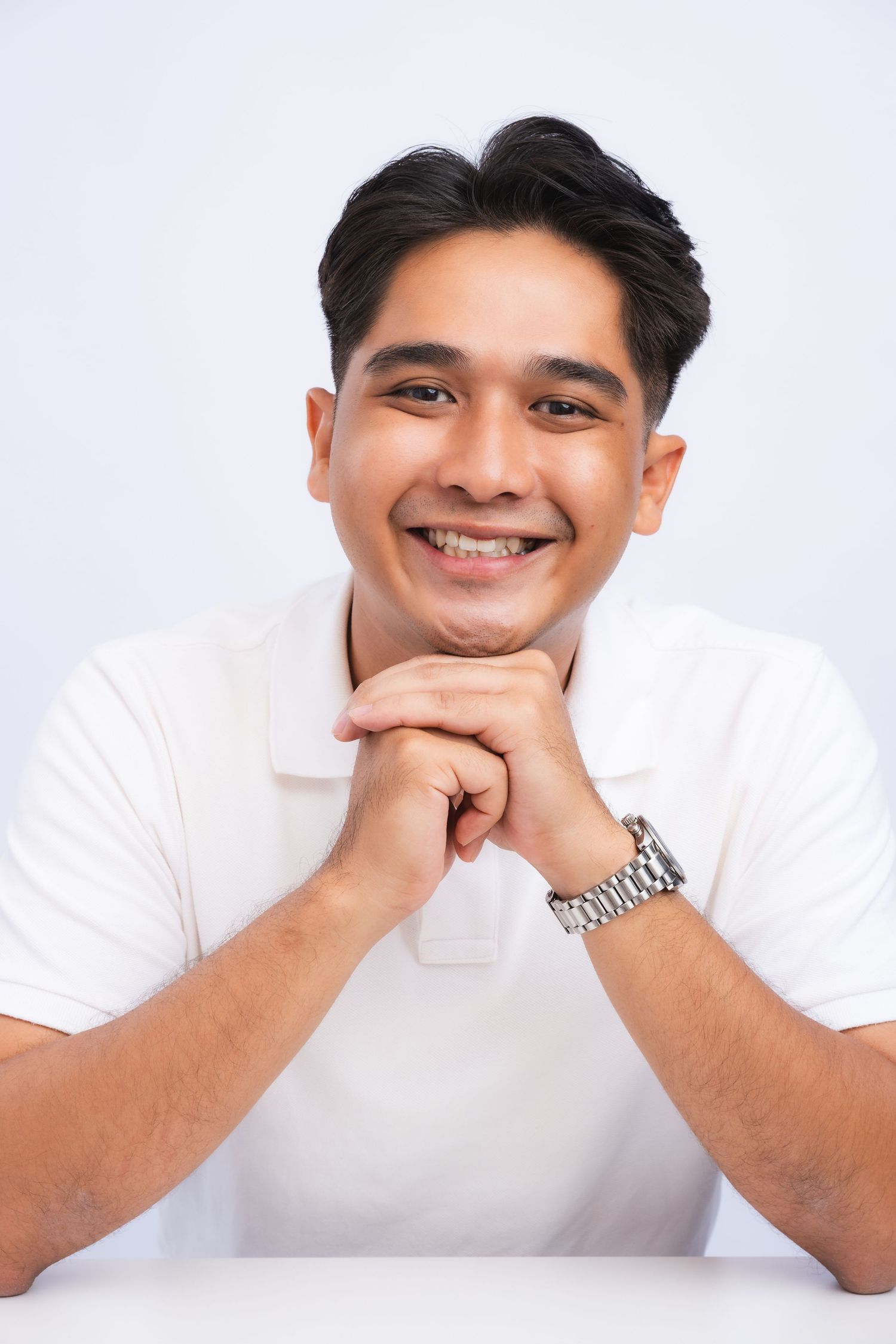 Portrait series in white polo shirt showing cheerful expressions against light background.