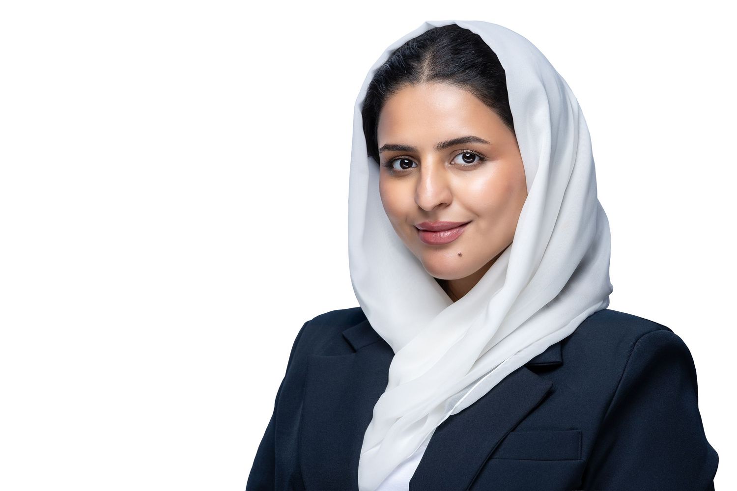 Professional portrait photo of someone in a white hijab and dark blazer against a light background.