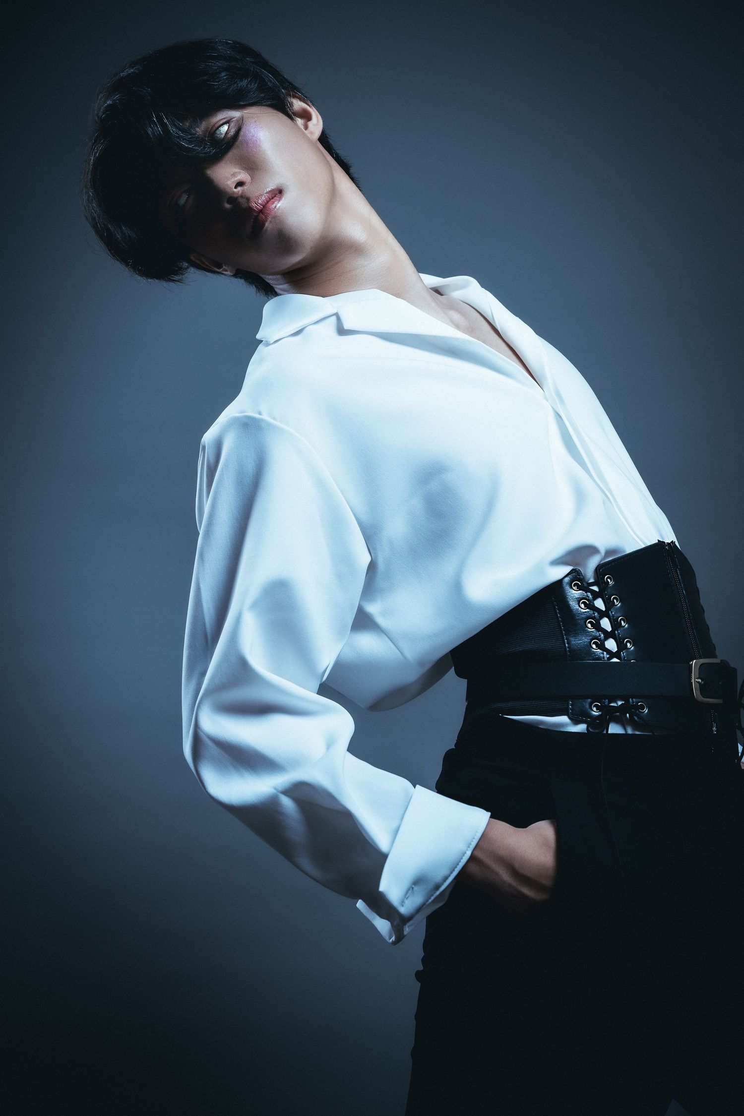 Fashion photoshoot featuring white top and black bottom ensemble with moody lighting.