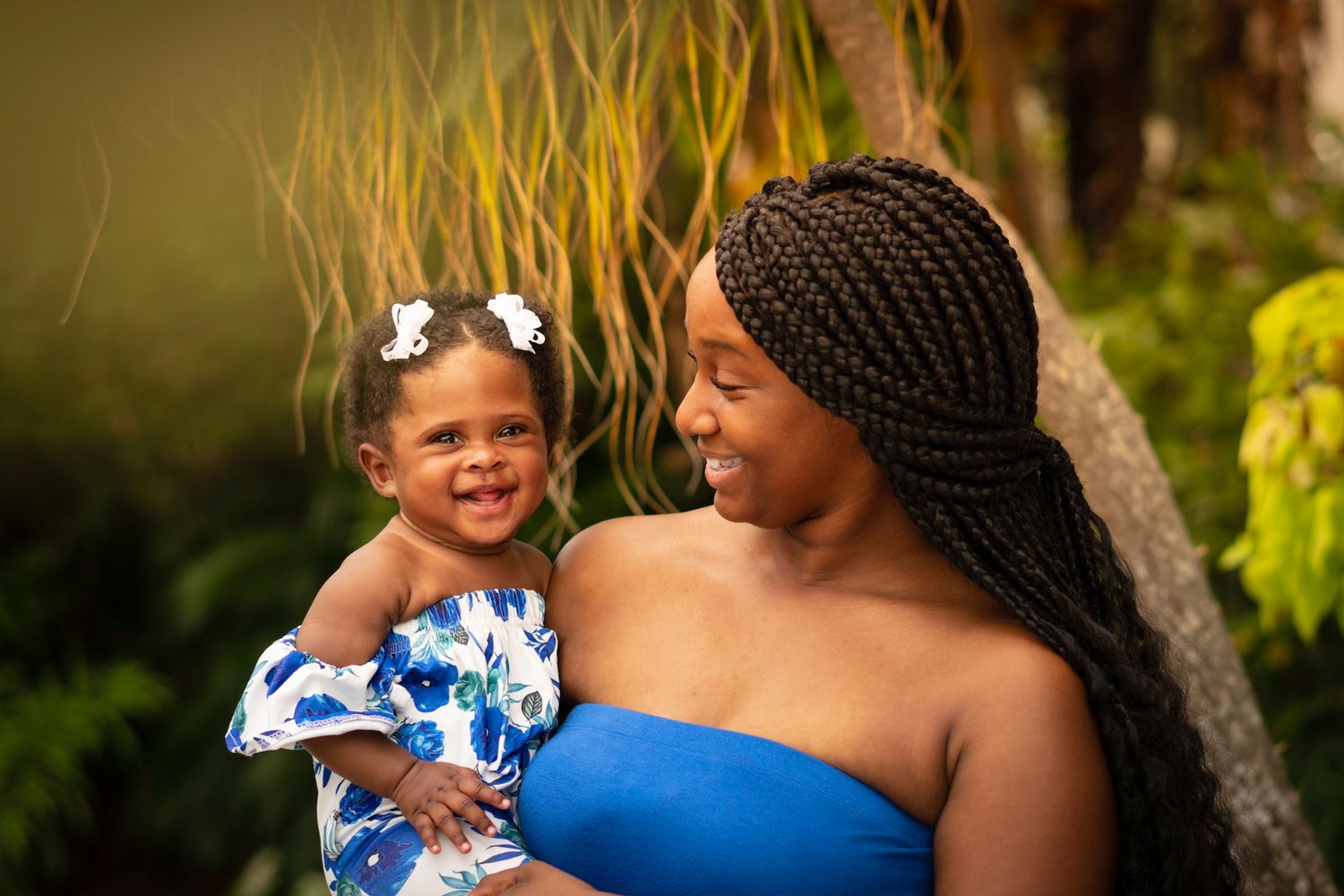 Sweet moments captured outdoors with natural greenery in the background.