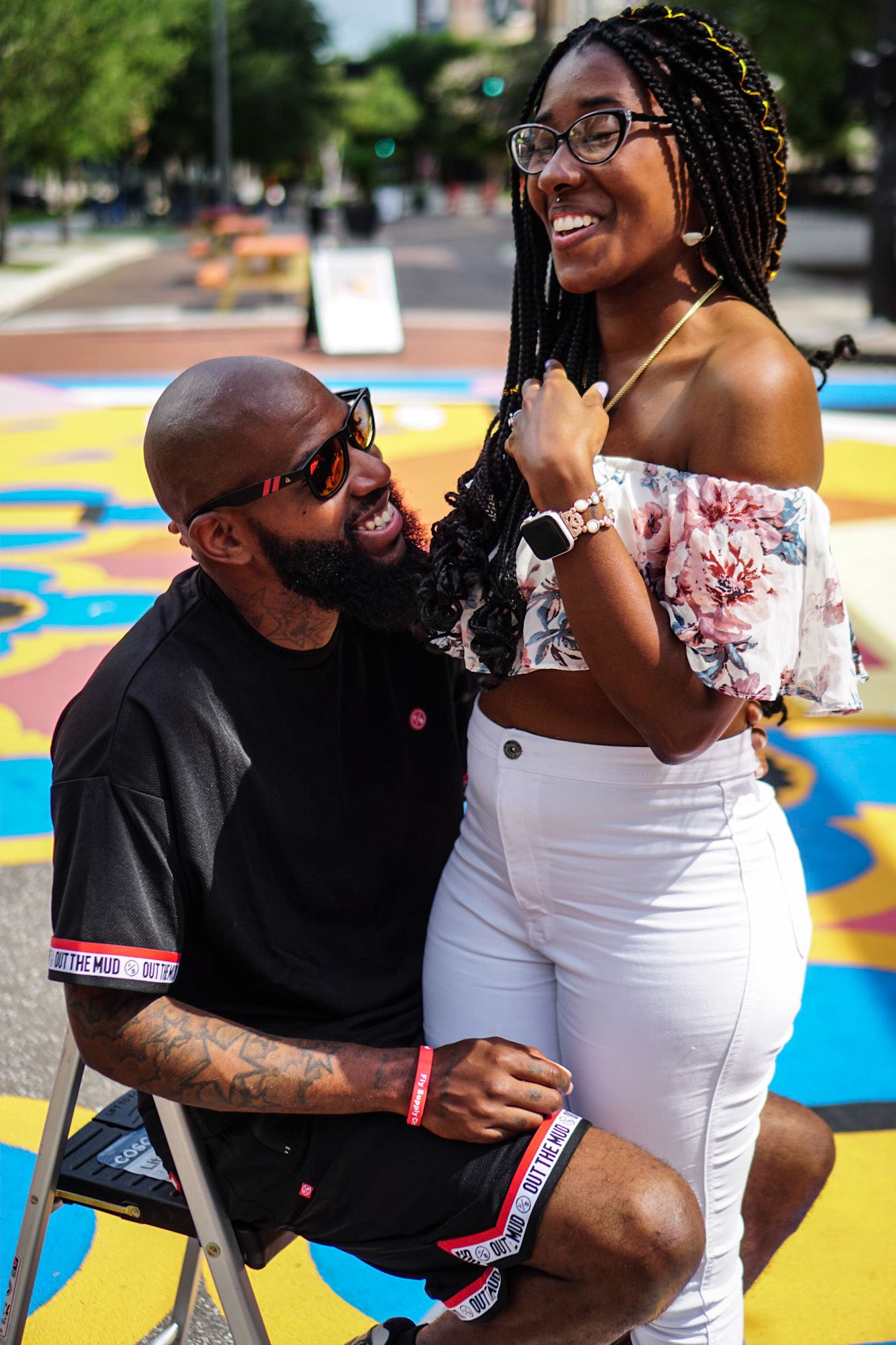 A couple shares joyful moments together against a backdrop of vibrant street art.