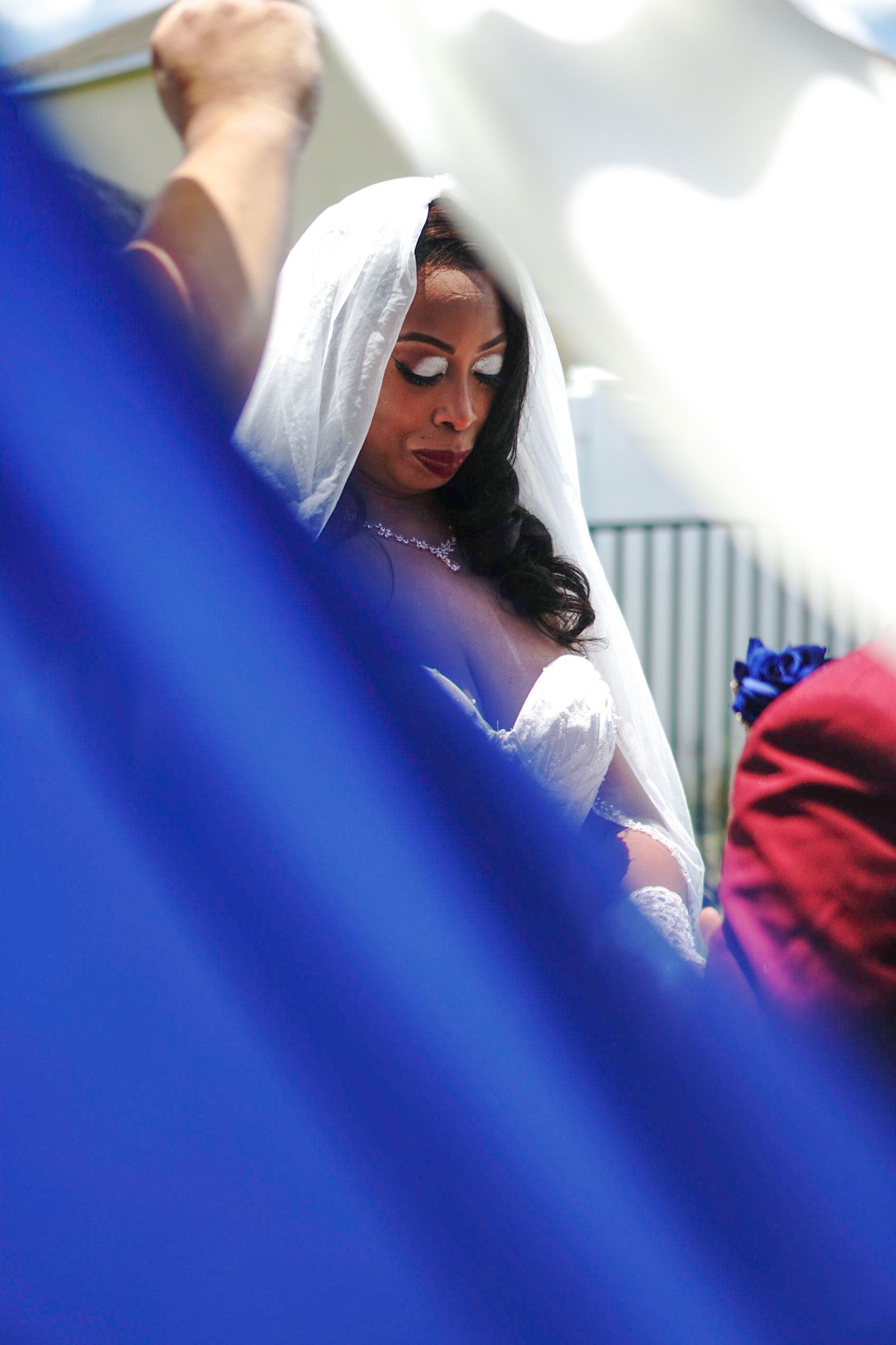 Close-up profile view of someone wearing a delicate white veil with elegant makeup.