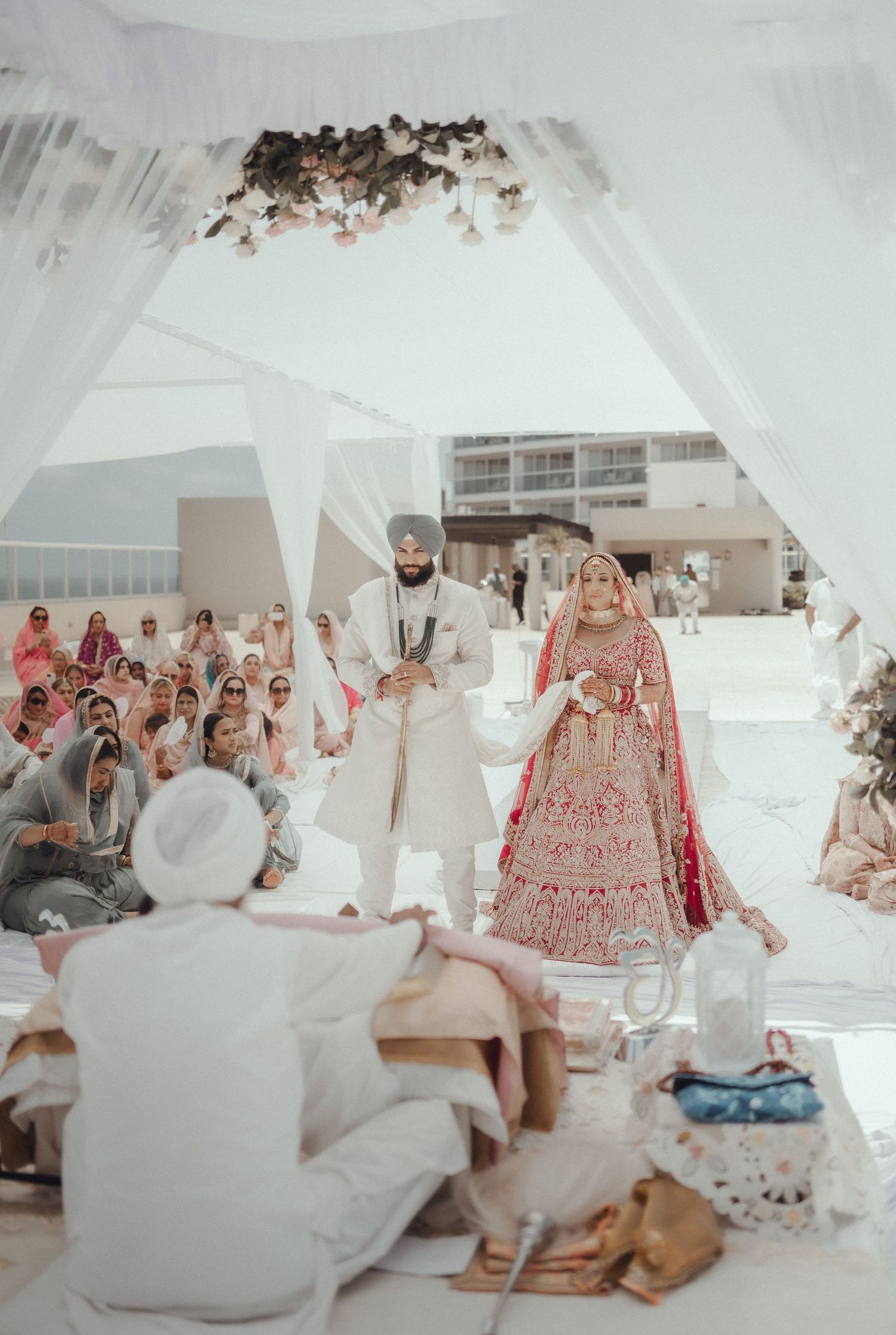 A group in traditional white and red attire gathered together for a cultural celebration indoors.