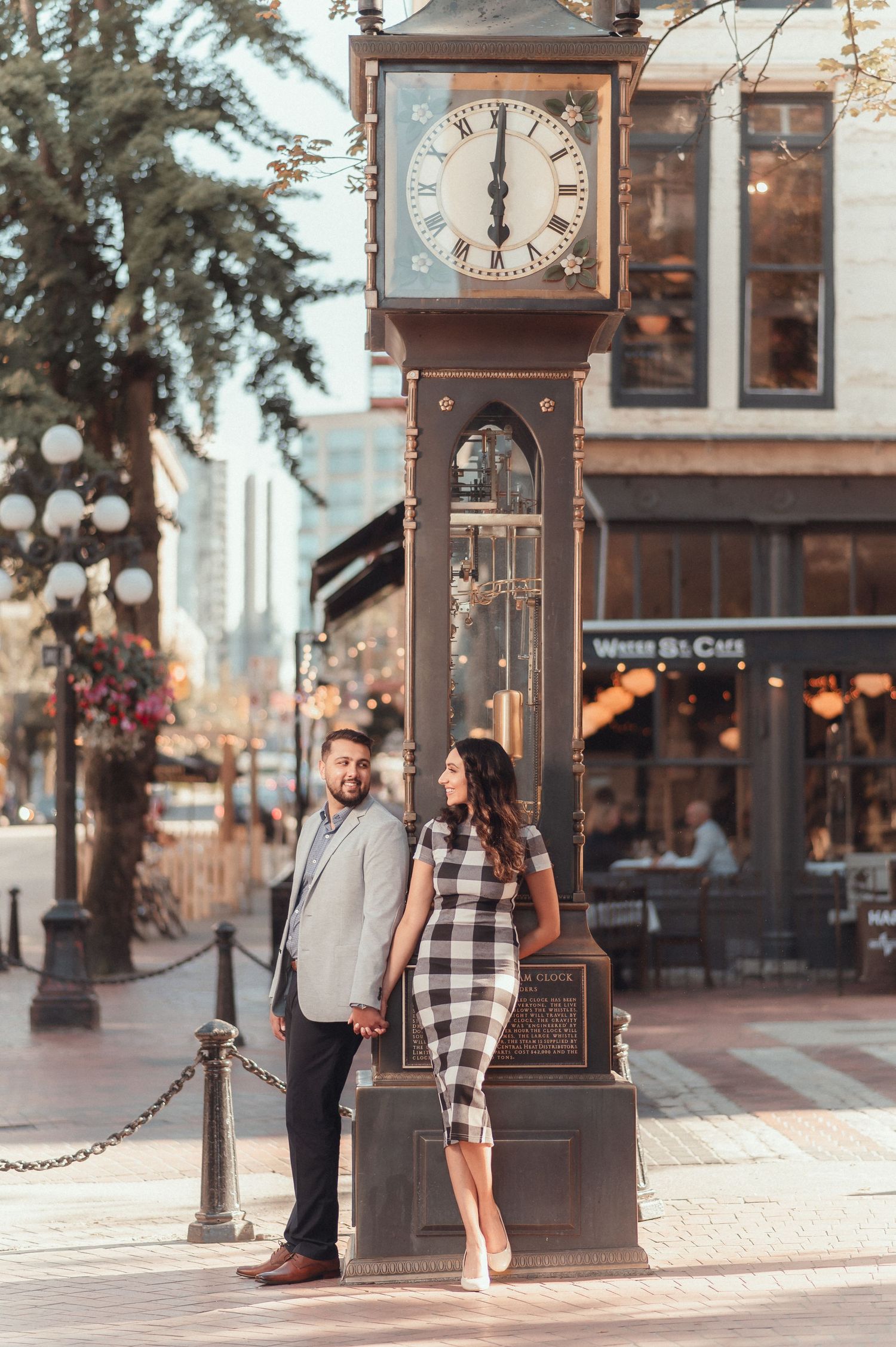 Couple sharing romantic moment by vintage street clock in urban setting.