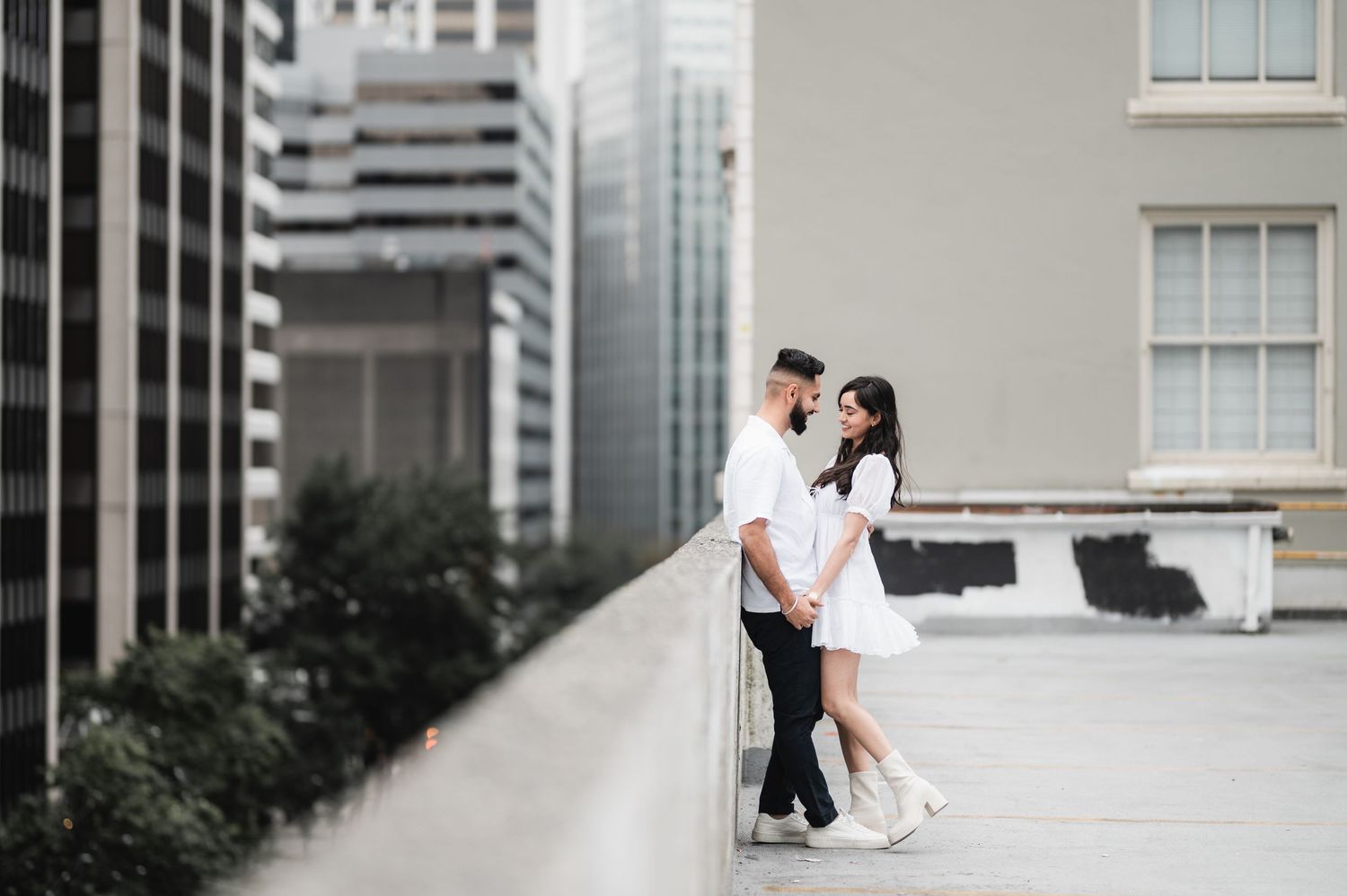 Modern urban photoshoot with couple against contemporary architecture.
