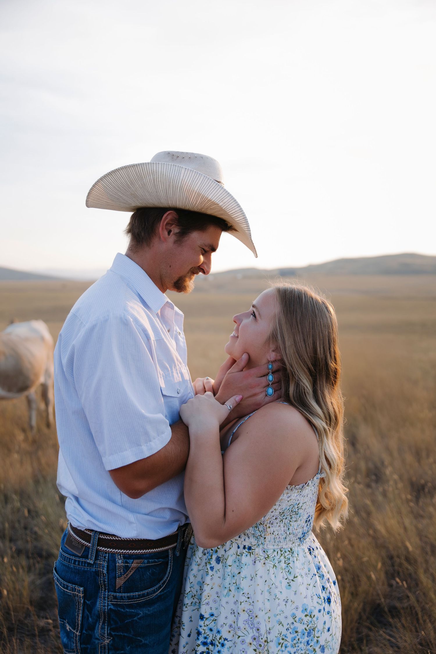 A romantic couple shares tender moments in a golden field at sunset.