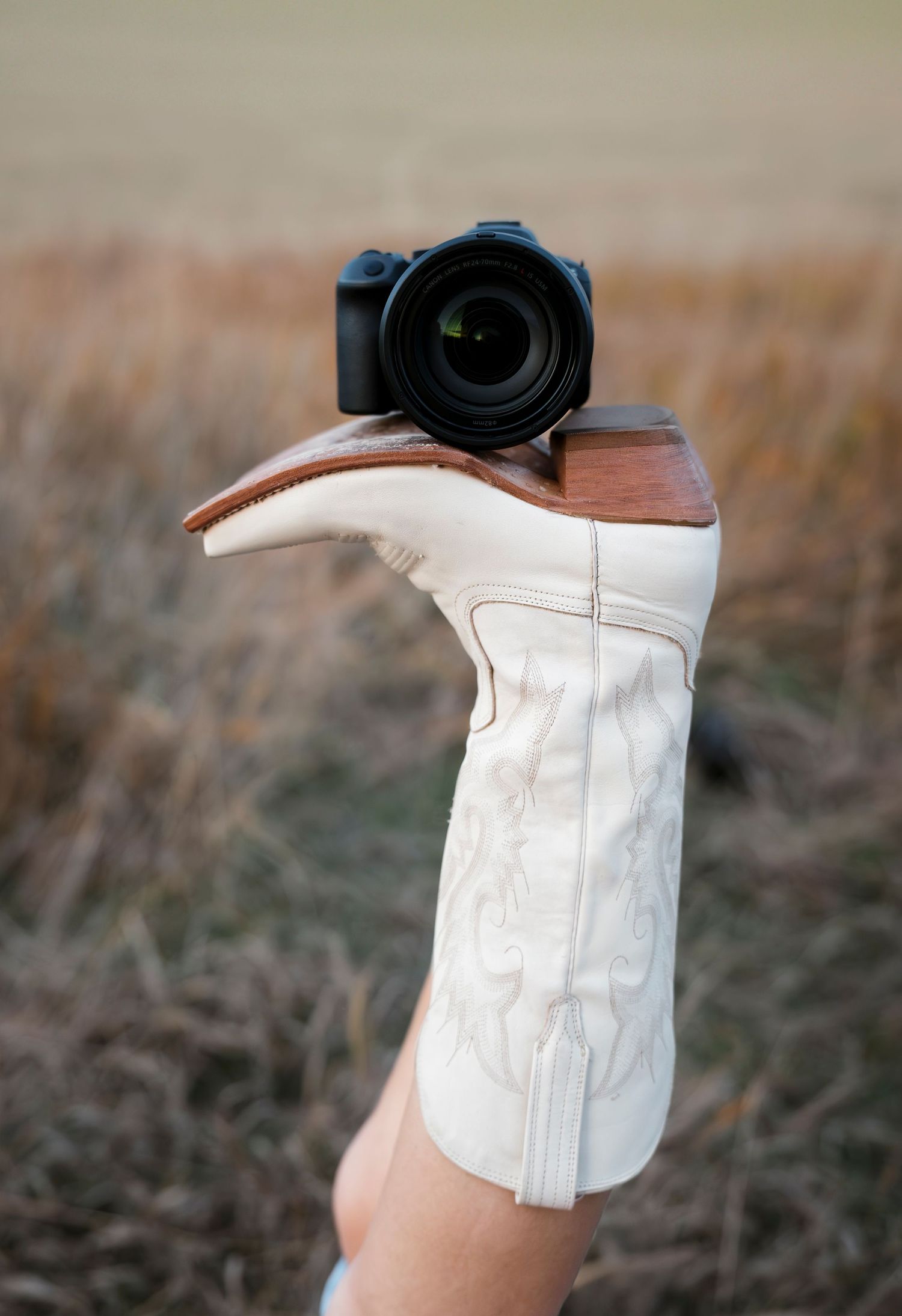 Close-up of a white leather boots with a camera posted on top.