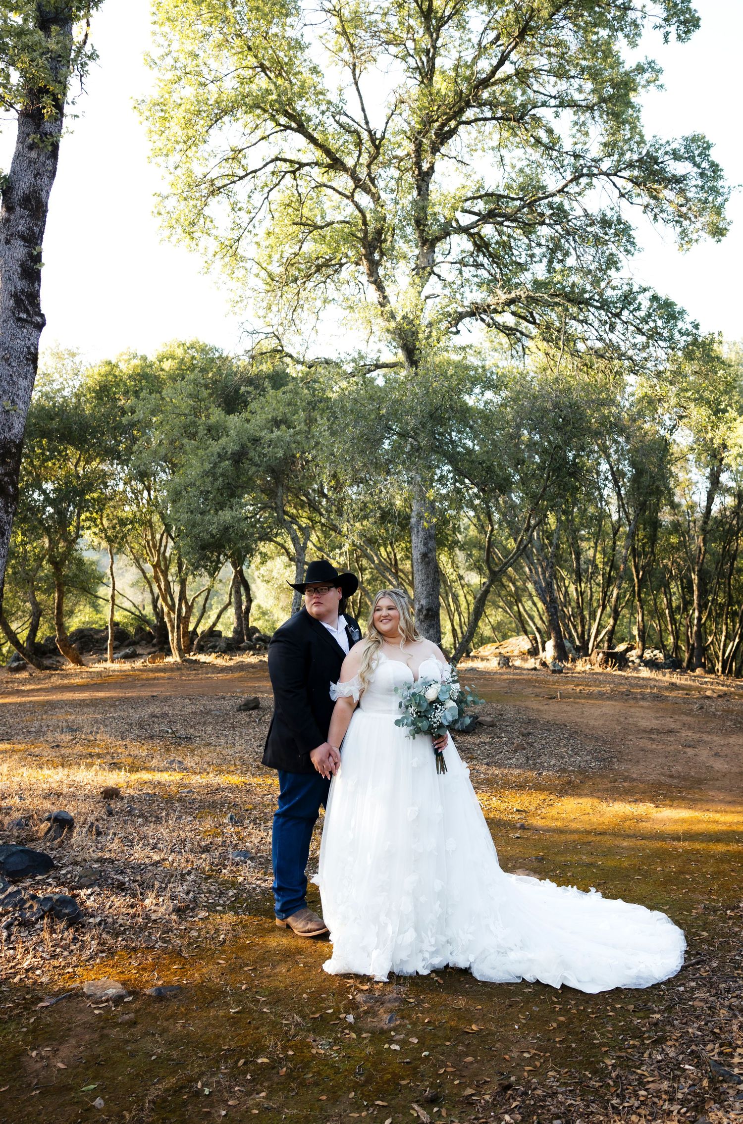 Western wedding photos with cowboy and his wife under a big tree