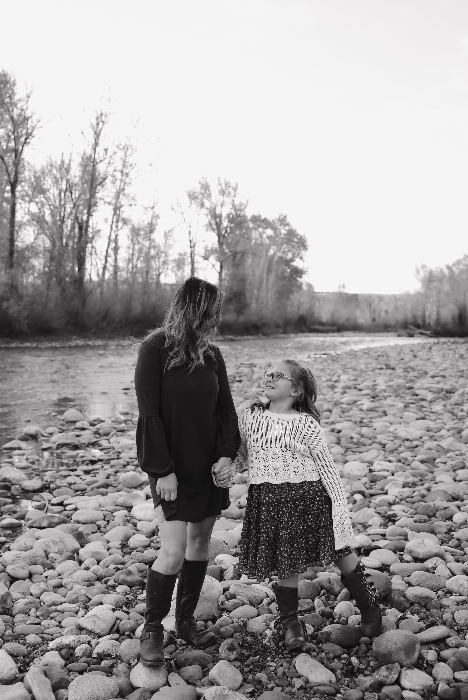 Black and white photo of people exploring a rocky riverbank together.