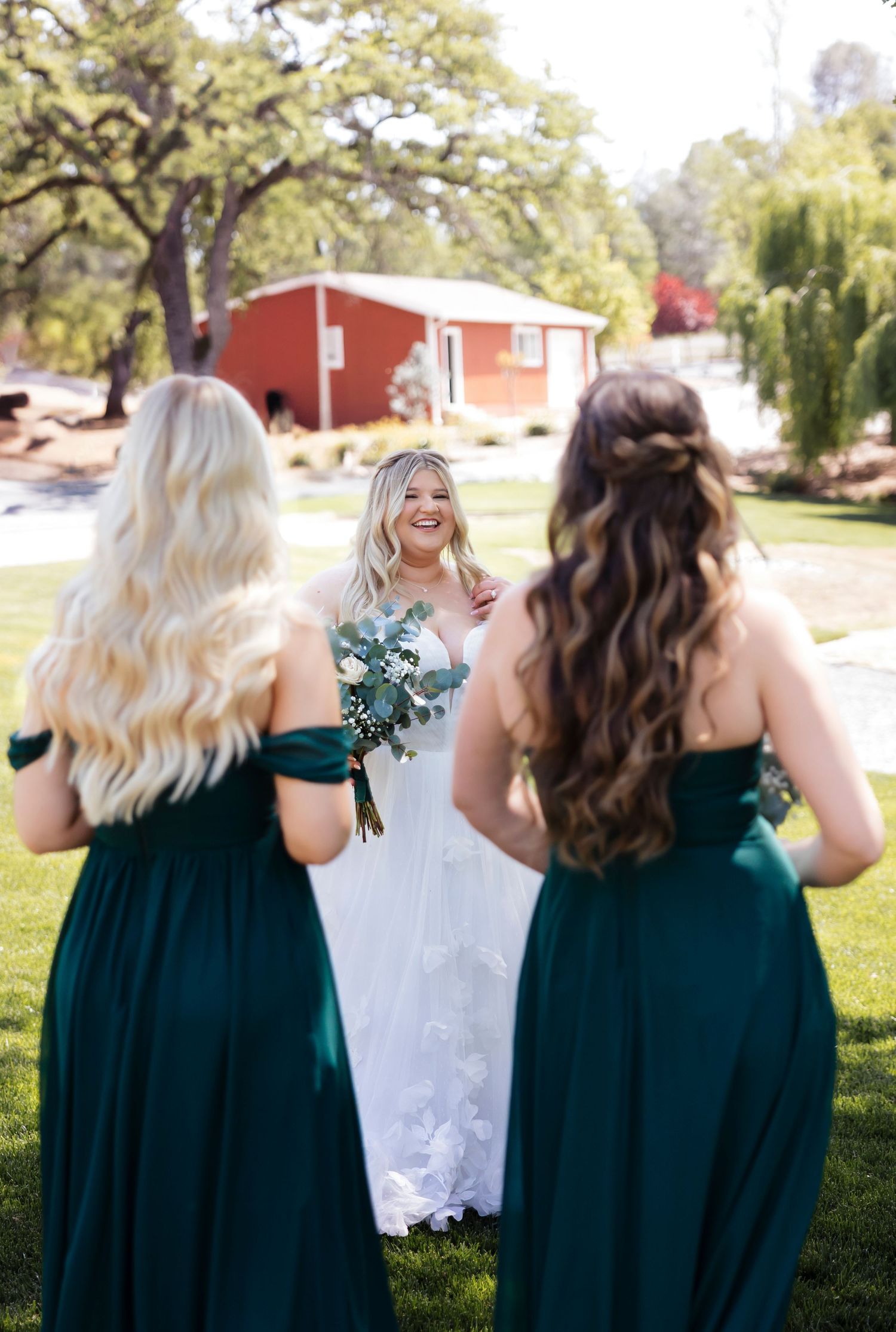 Wedding party in emerald green dresses walking outdoors.