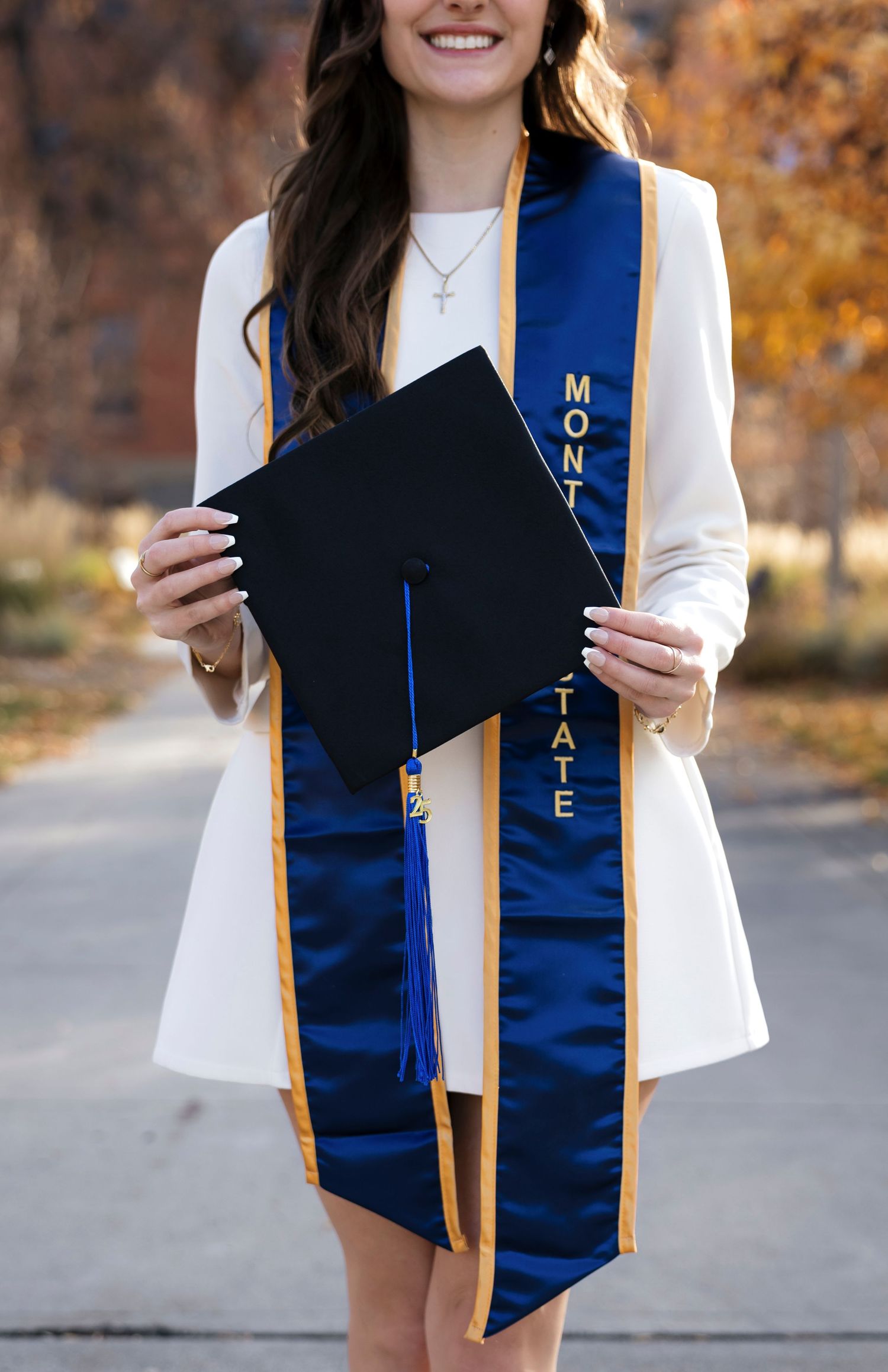 Close-up of blue and gold graduation stole with decorative elements.