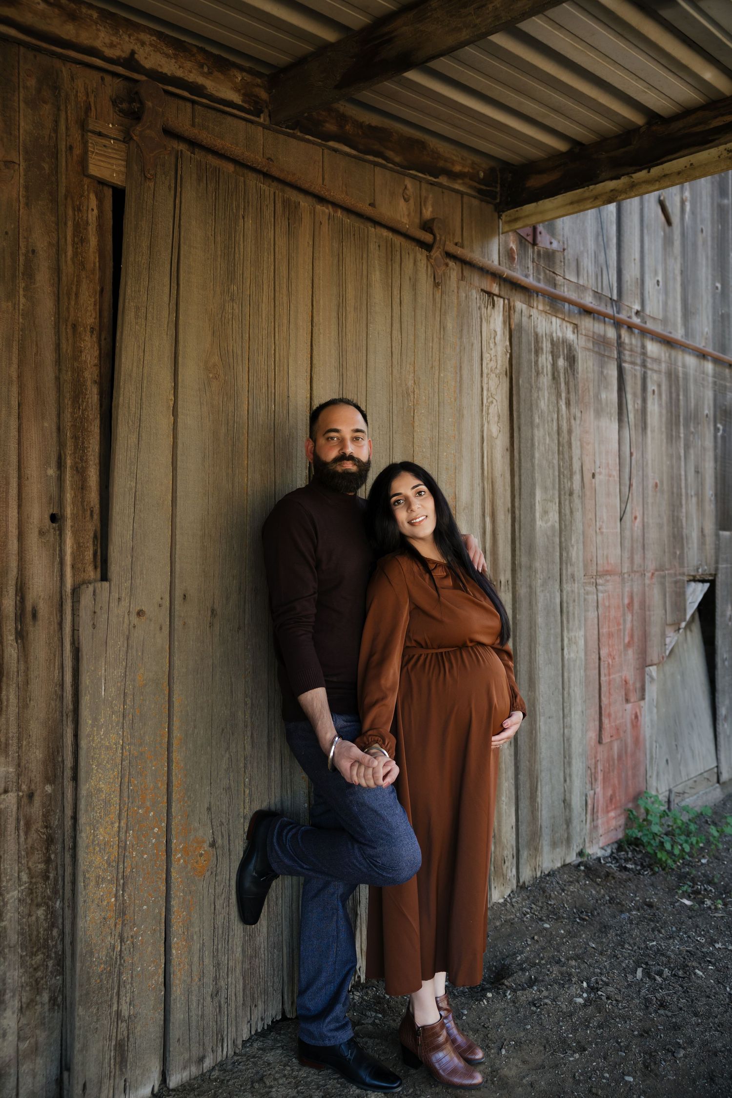 Rustic wooden backdrop creates moody atmosphere for intimate portrait session.