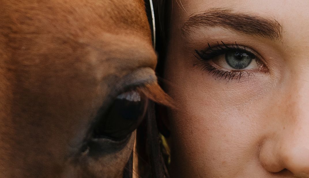 Extreme closeup of bright blue eyes with long eyelashes and defined eyebrows.
