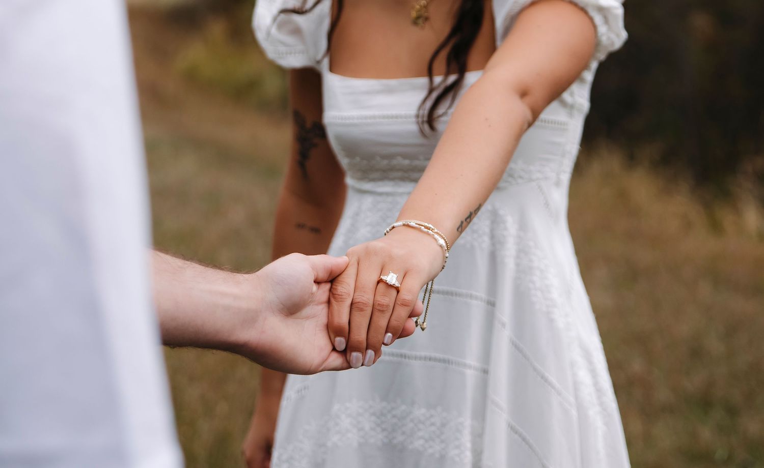 Close-up detail of hands touching in soft natural light.