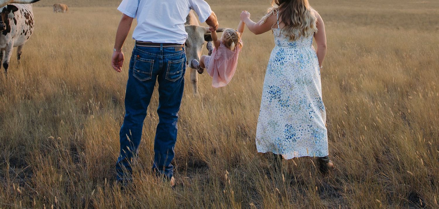 Candid moments of people dancing and twirling in tall grass field at sunset.
