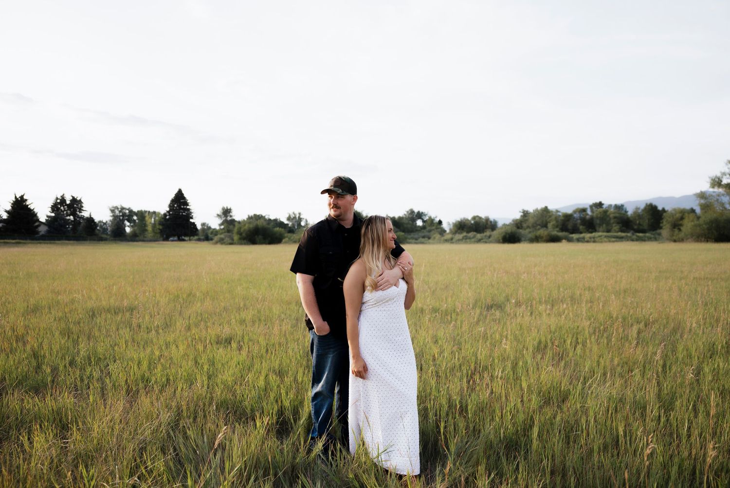 An engaged couple in a grassy field in Montana