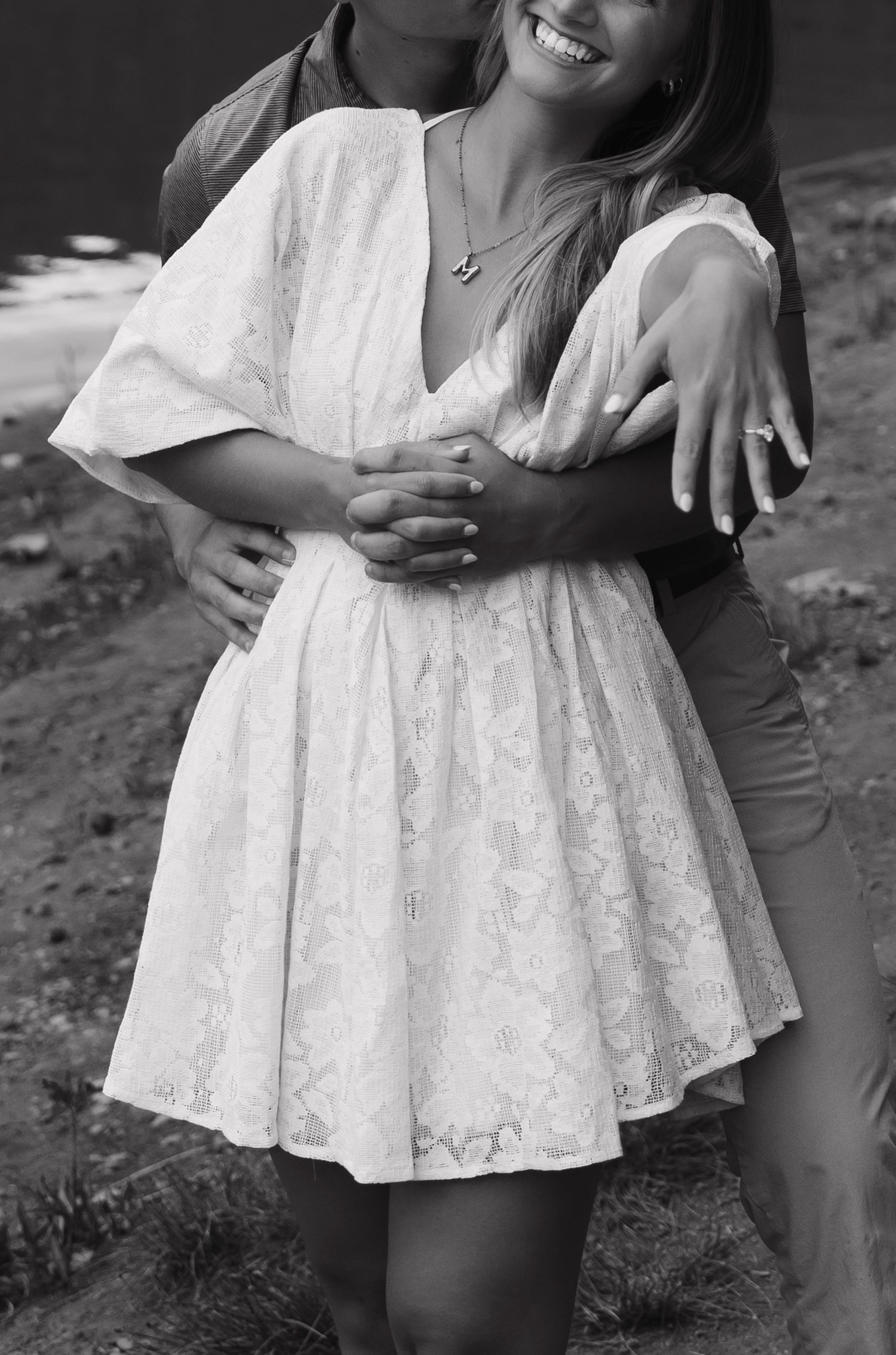 Woman wearing white lace dress poses in black and white portrait series.