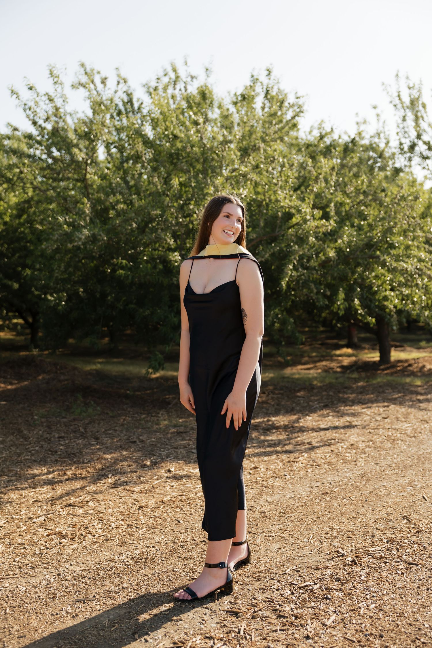 Elegant portrait session among orchard trees at golden hour.