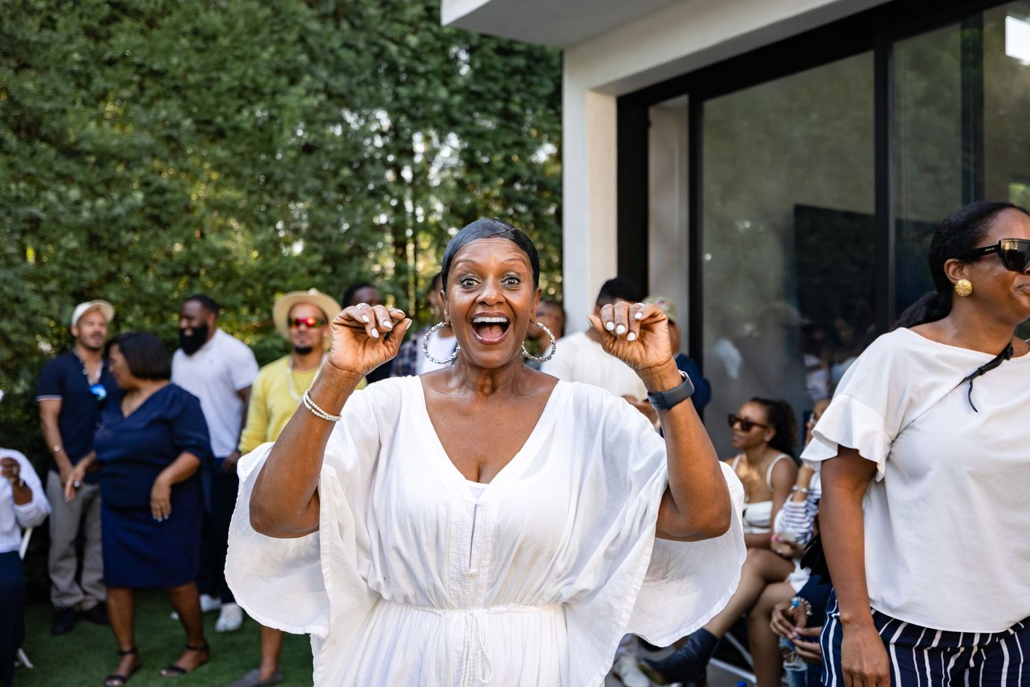 People dancing and celebrating joyfully at an outdoor gathering.