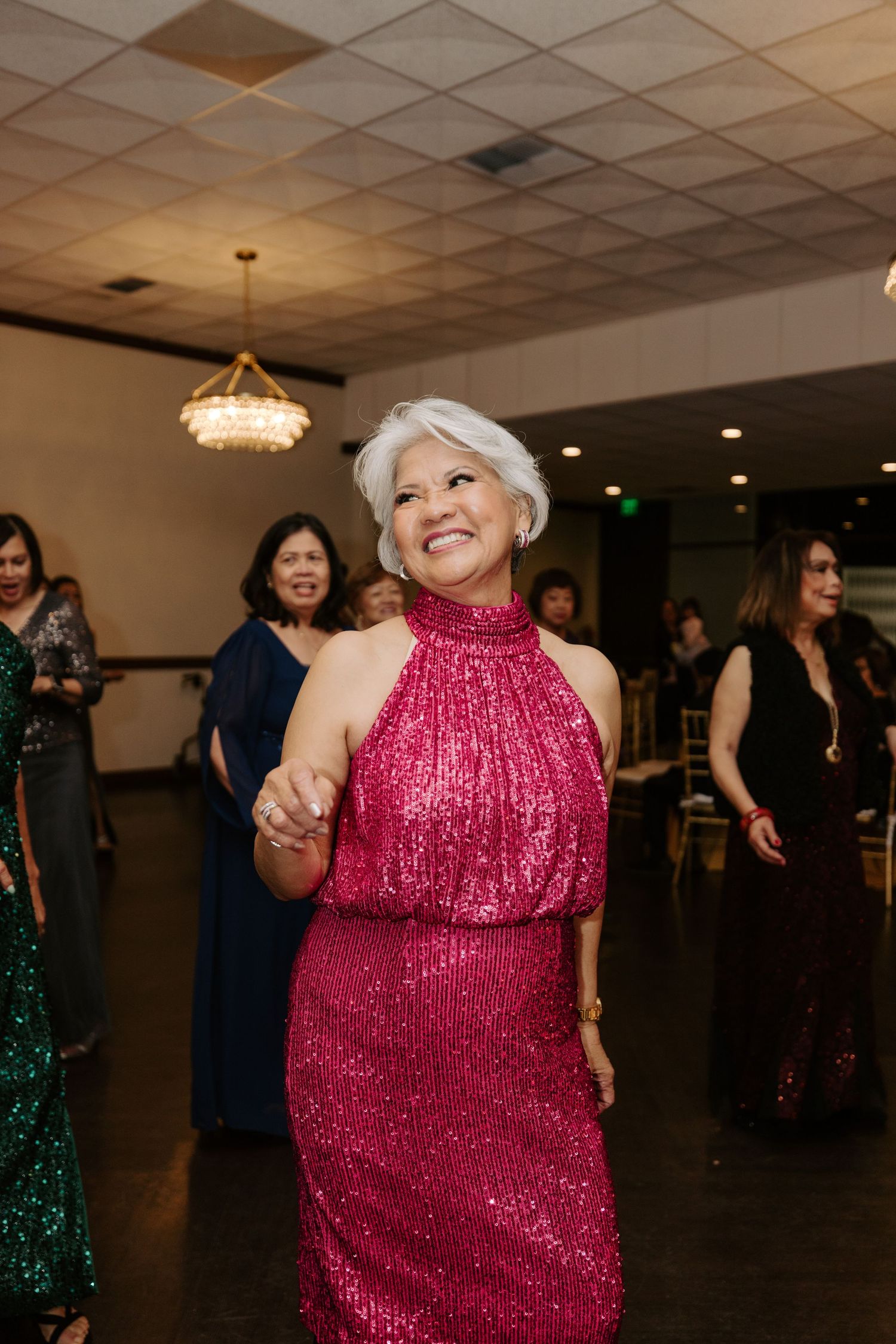 Dance floor with people enjoying themselves at a party with sparkling formal attire.