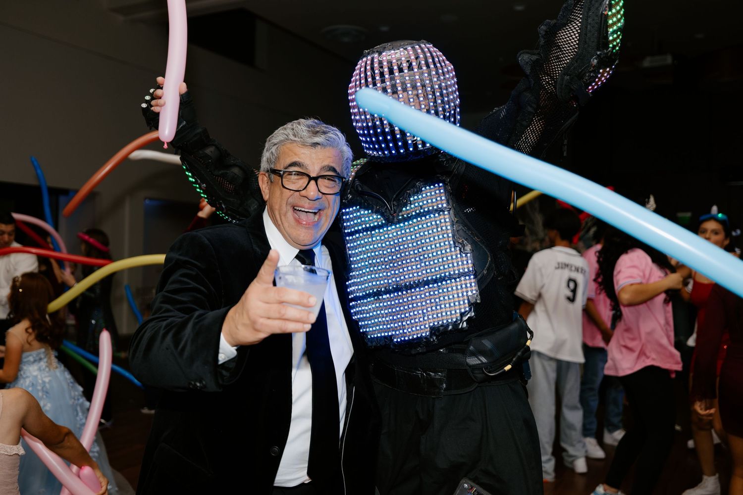 Party scene with glowing accessories and festive lighting effects.