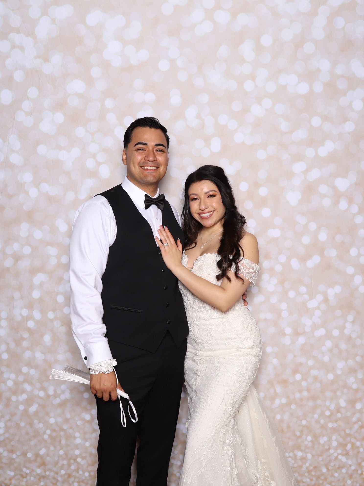 A couple poses together in formal attire against a sparkly backdrop in a series of four photo booth style images.