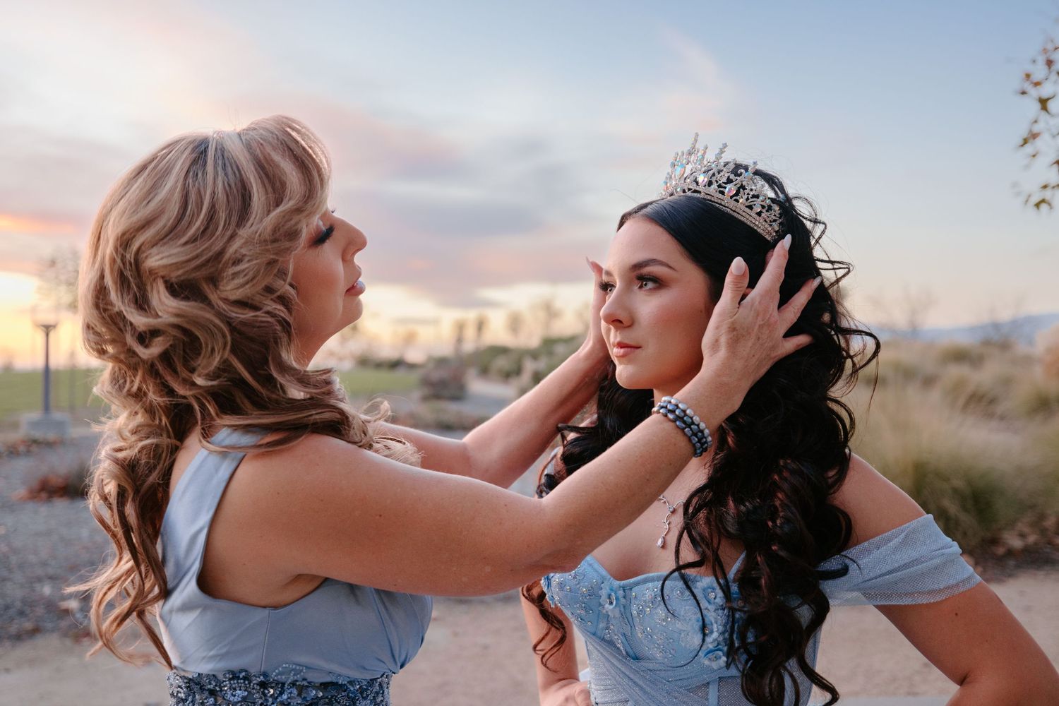 Outdoor sunset preparation moment with styling happening against mountain backdrop.