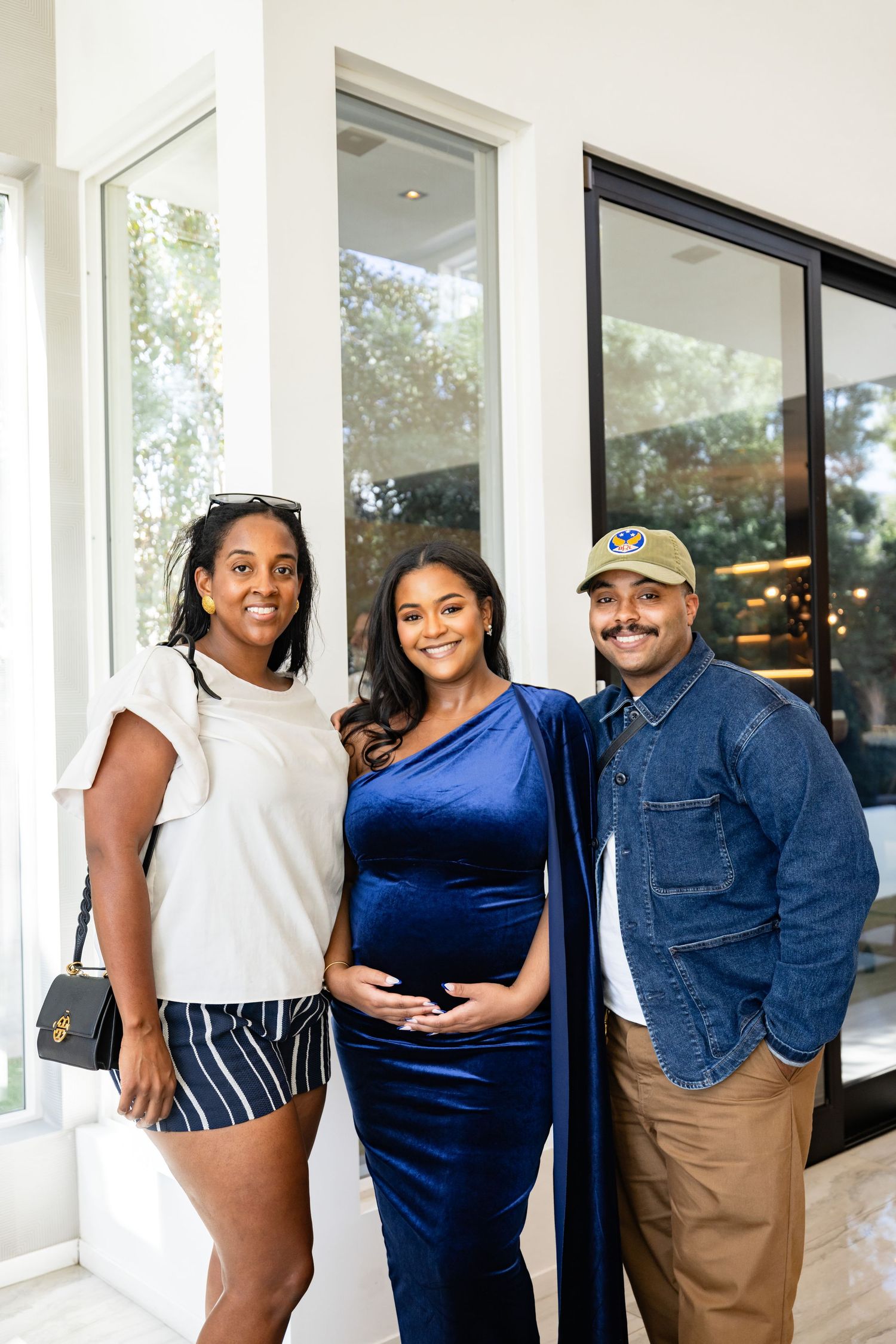 Three guests posing together at an elegant baby shower celebration.