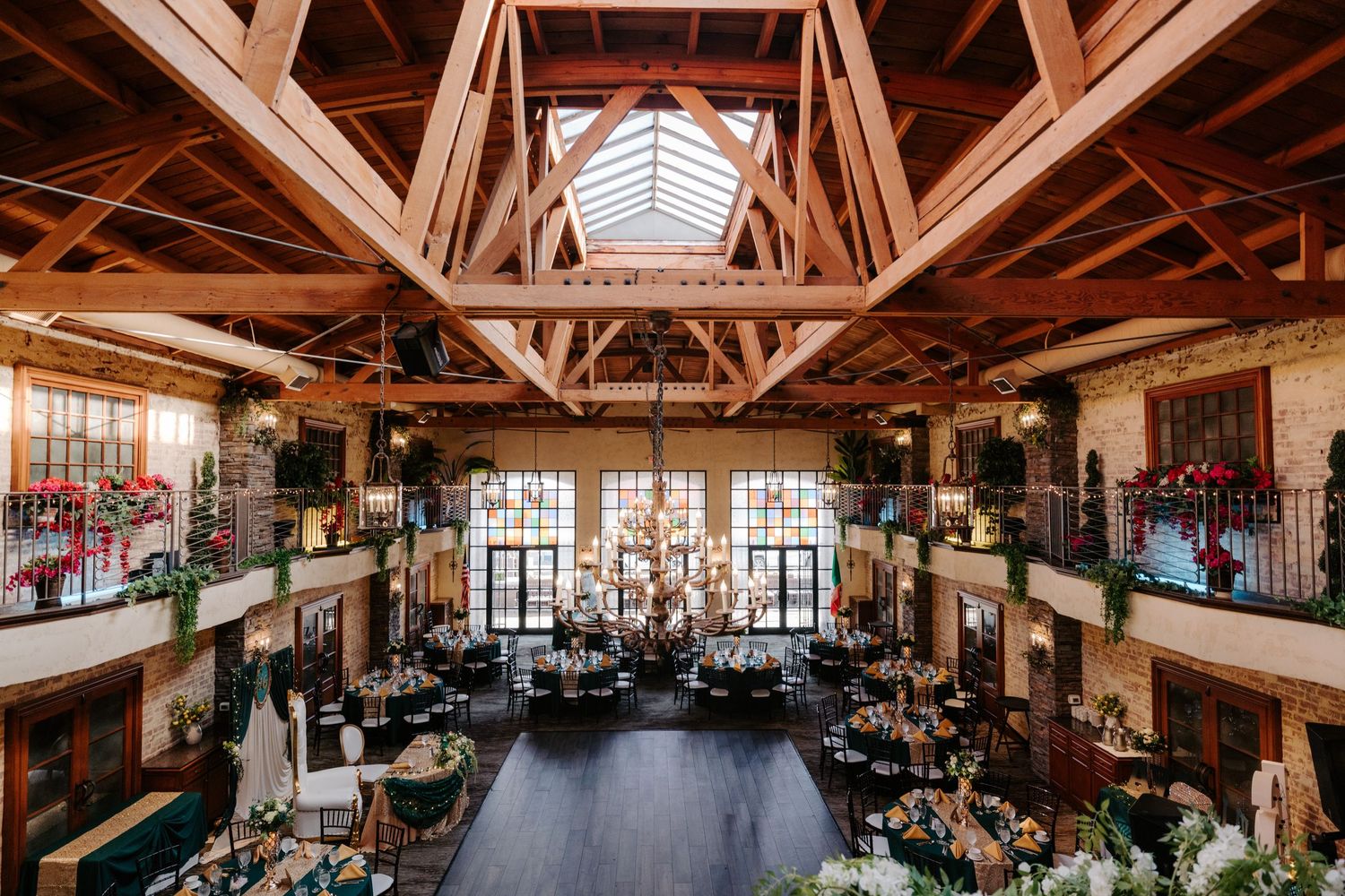 Rustic wooden event venue with exposed beams and natural lighting features elegant table settings for a wedding reception.
