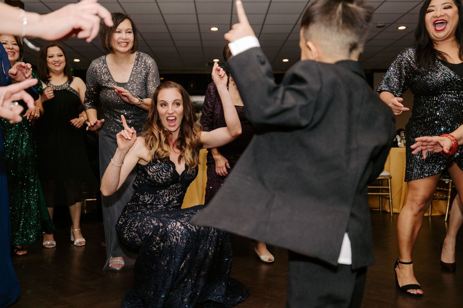 Guests dancing and celebrating energetically on a dimly lit dance floor.