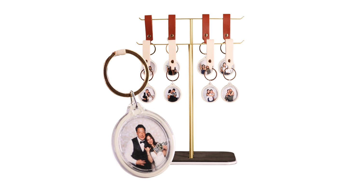 Metal jewelry display stand with dangling earrings and a circular photo locket pendant in rose gold tones.