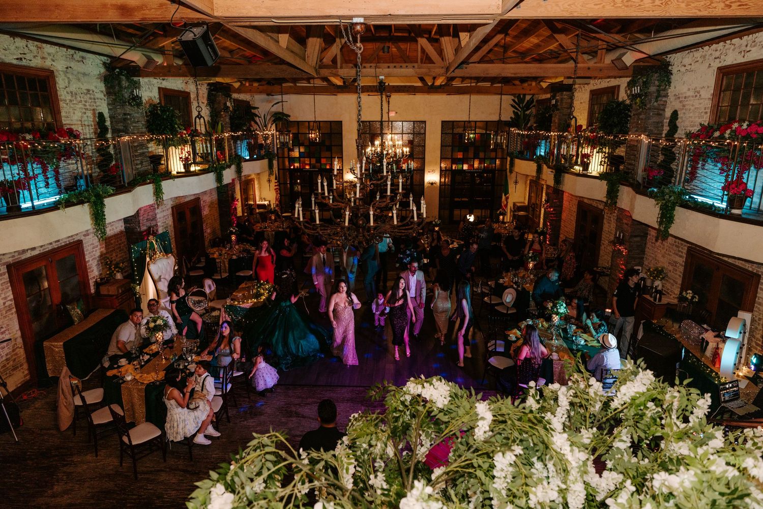 Wedding reception venue decorated with elegant floral arrangements and purple lighting for evening celebration.