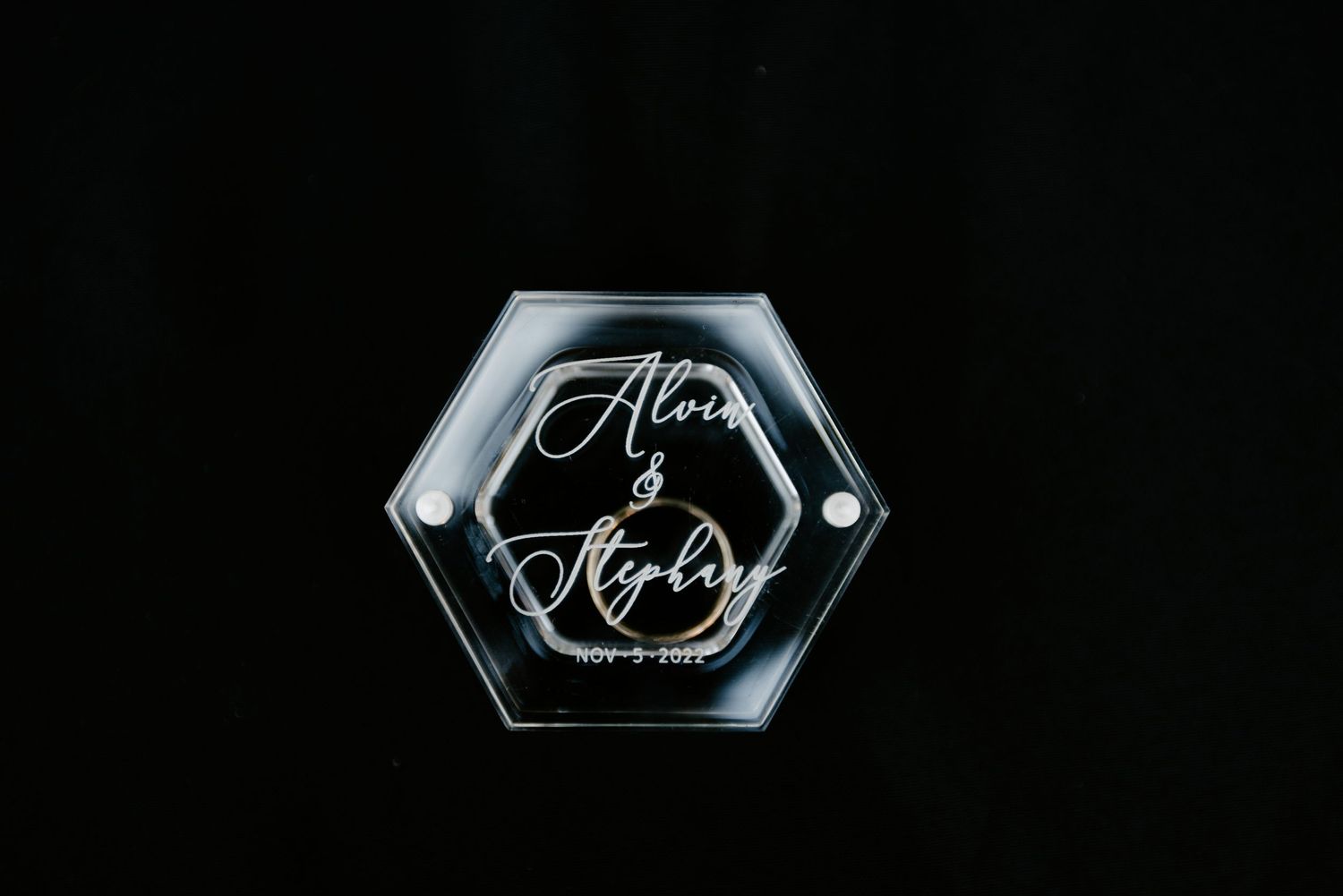 Elegant hexagonal glass wedding signage displayed against dark background.