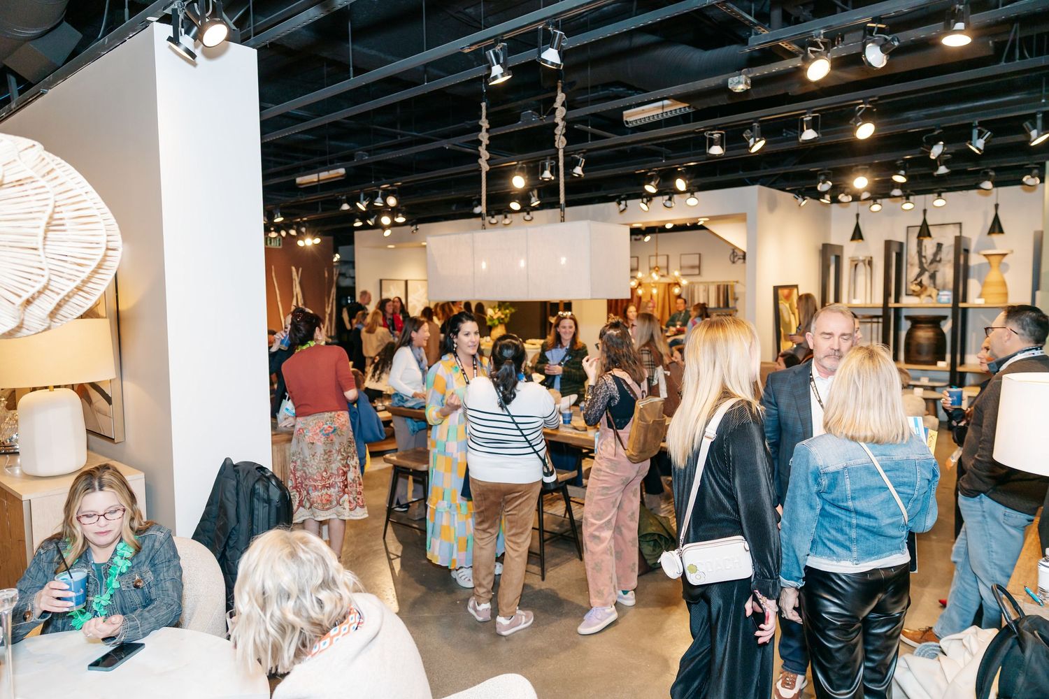 Crowd of interior design professionals networking inside a modern home furnishings showroom.