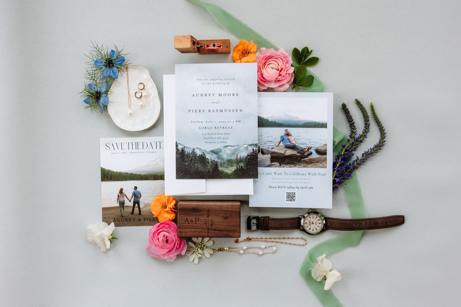 Romantic wedding invitation suite with mountain lake photo styled with roses, watch, and ribbon.