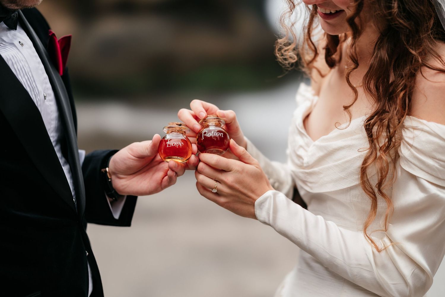 Bride and groom exchanging wedding rings in small red boxes during their ceremony.