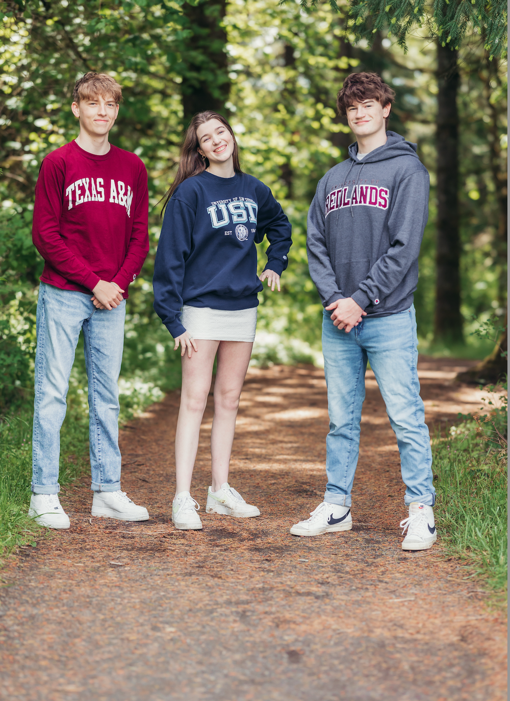 Three high school seniors standing together on a forest trail in Portland Oregon