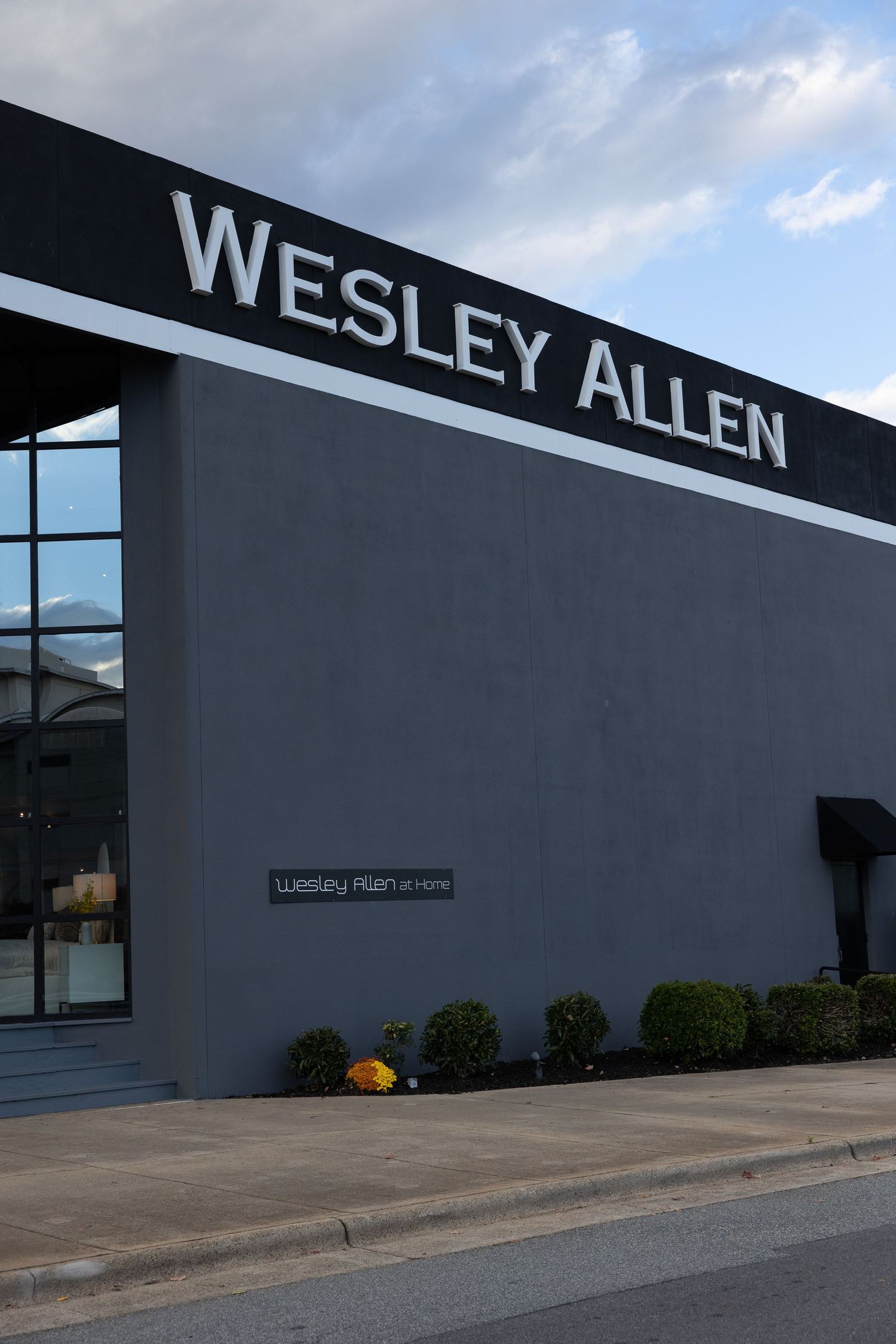 Exterior view of Wesley Allen furniture showroom building at dusk.