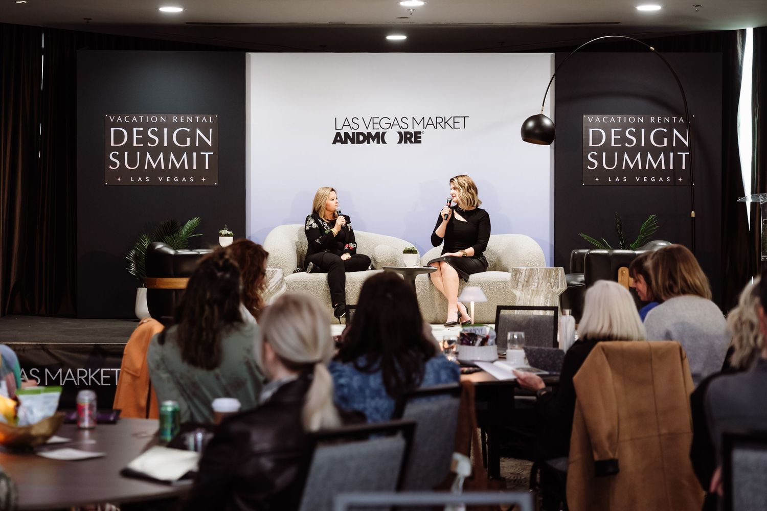 Two women on stage presenting at the Vacation Rental Design Summit in Las Vegas.