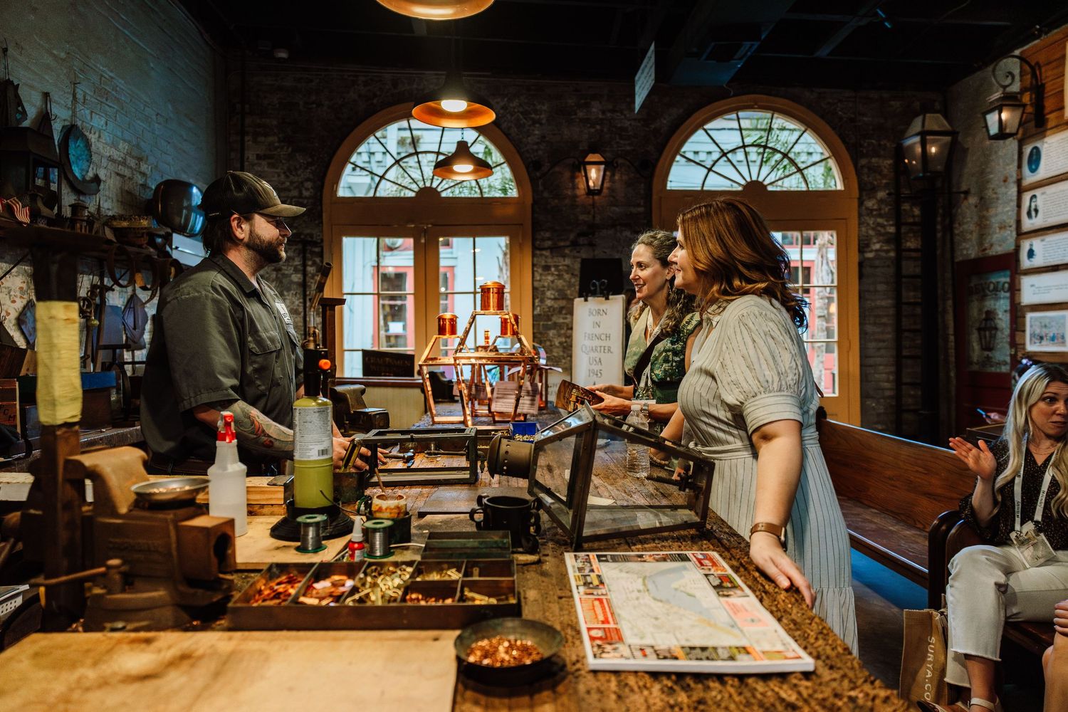 Customers ordering at a rustic brick interior restaurant counter with colorful stained glass windows.